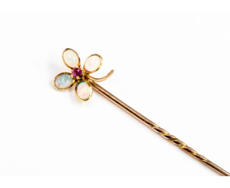 An opal and ruby four leaf clover rose metal stick pin, the leaves formed as opal cabochons with faceted ruby to centre and r