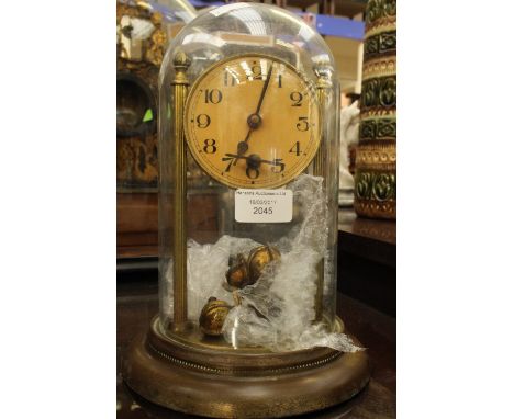 An anniversary/perpetual clock, early 20th Century with key, glass dome, brass (af) 