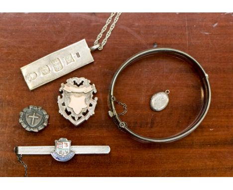 Five items of silver jewellery, comprising two shield brooches, one ingot and chain, the slide and bangle weighing 86.3 grams