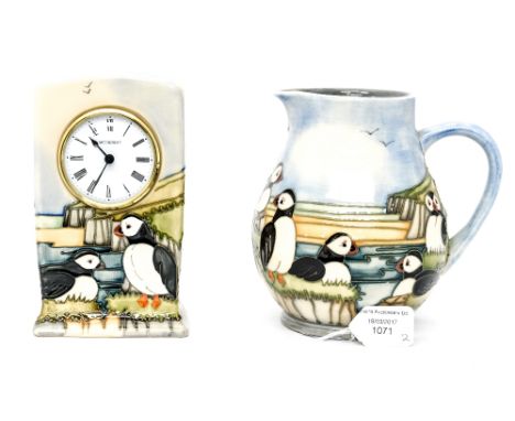 A Moorcroft Puffin design jug, with a Moorcroft Puffin design mantle clock (both silver line to base) (2) 