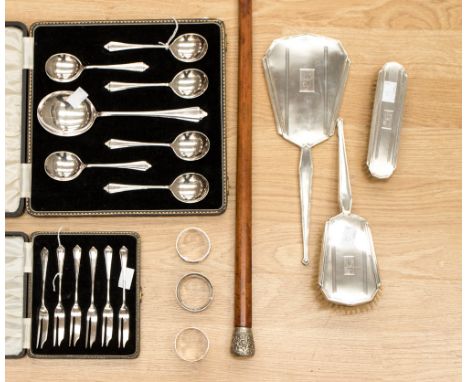 An Art Deco three-piece silver dressing table setcomprising mirror and two brushes, Birmingham, 1922, three silver napkin rin