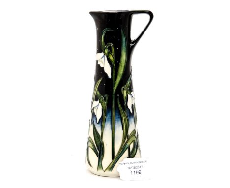 A Moorcroft pitcher in the 'snowdrop' pattern, measuring approx 18.5cm high