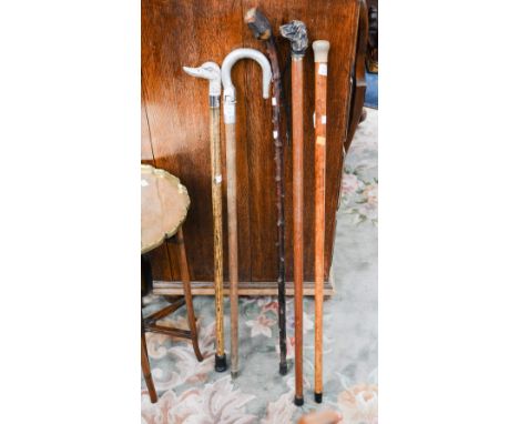 Four walking sticks - bone finial, dogs head and ducks head finial; together with a shooting stick (5) 