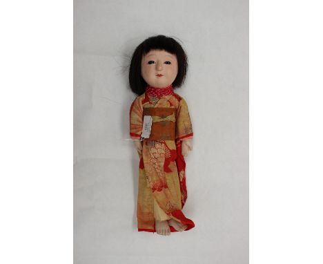 A Japanese doll dressed in a screen printed Kimono with hand stitched detail, tie tied silk neck scarf, real hair, possibly p