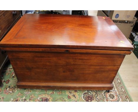 A large mahogany trunk, the large lid opening to reveal a single storage section