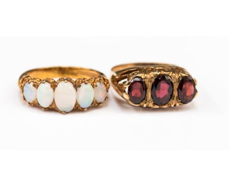 A garnet dress ring set with three oval faceted garnets in 9ct yellow gold ring size N; together with a 5 stone opal ladies d