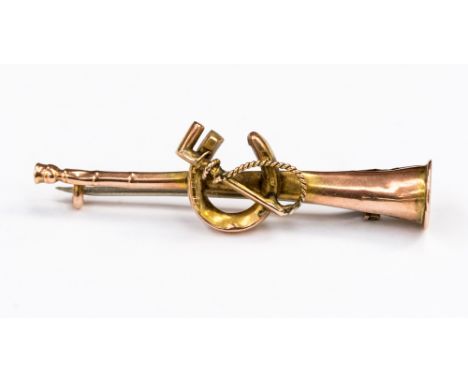 A nine carat yellow and rose gold  bar brooch (hunting interest); horn, whip and horse shoe design and has a length of approx