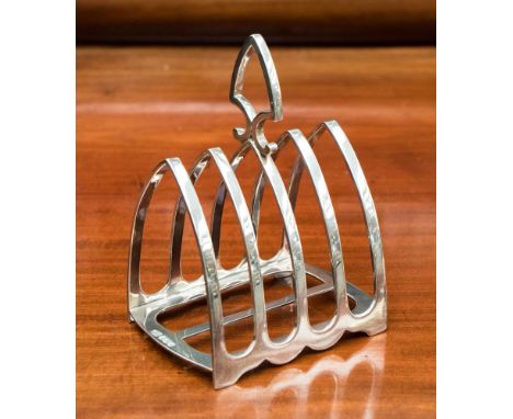 An Edwardian silver four tier toast rack of Gothic form, Sheffield 1905, makers mark for George Howson & Harrison Brothers, a