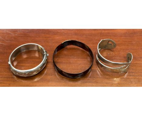 A 1930s tortoiseshell overlap bangle, a hollow silver bangle, 20.9 grams, 0.99 ozt approx, Chester hallmark 1957, a white met