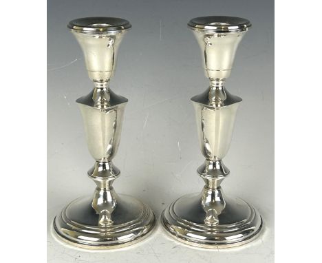 A pair of sterling silver candlesticks, 19 cm high and a&nbsp;silver coloured metal salt and pepper, in a fitted case