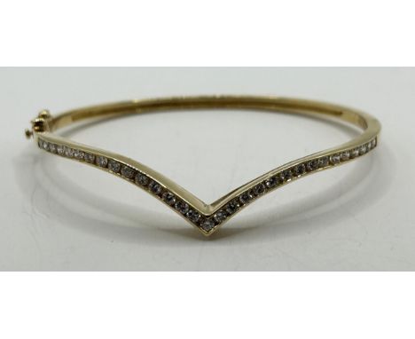 An 18ct gold and diamond set wishbone hinged bangle