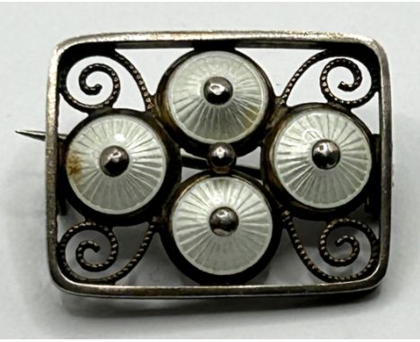 A silver and white enamel brooch