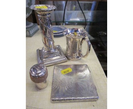 A silver cigarette case, silver candle stick, silver mug with engraved decoration, and hallmarked silver bottle stopper