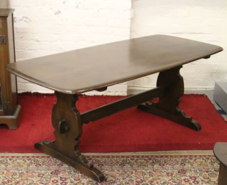 A large dark oak Ercol refectory dining table.