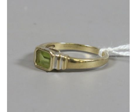 A ladies 9ct gold and baguette cut peridot dress ring, UK size Q. 2.51 grams.