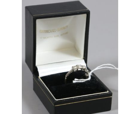 An Art Deco 18ct gold and platinum three stone diamond ring, size O.