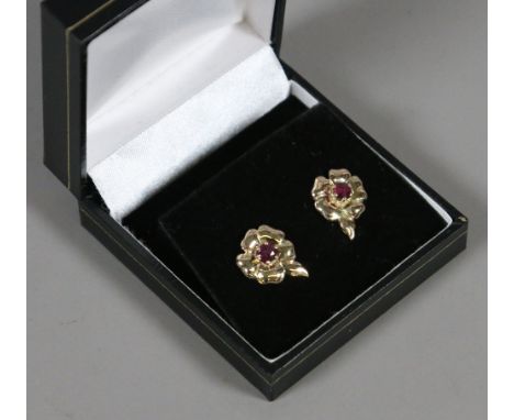 A pair of 9ct gold and ruby floriform stud earrings.