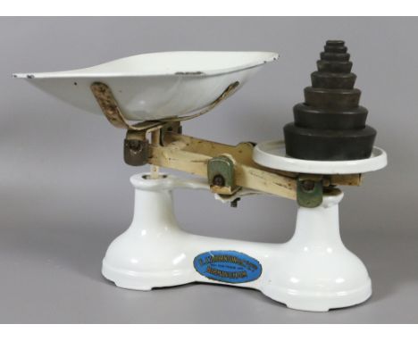 A set of white enamel kitchen scales and weights.