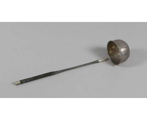 An antique white metal toddy ladle with whale bone handle and set with a Queen Anne coin.