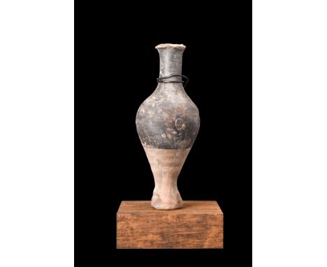 Ca. 200-100 BC.A pottery unguentarium with its spindle form body is elegantly shaped, with a stem foot and flared base that p