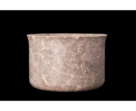 Ca. 2nd millennium BC.A stone vessel characterized by its cylindrical shape, featuring straight walls that rise vertically fr