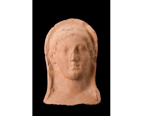 Ca. early 5th century BC.A rare terracotta protome, featuring a breathtaking visage of a goddess with ethereal beauty. This m