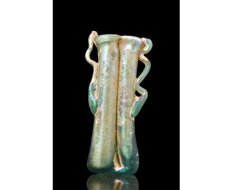 Ca. 300 AD.A beautiful double balsamarium crafted from greenish glass. The vessel is composed of two conjoined tubular phials