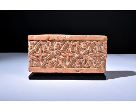 Ca. 1100-1200 AD.A rectangular-shaped terracotta tile adorned with intricate details. The upper face is graced by a symphony 