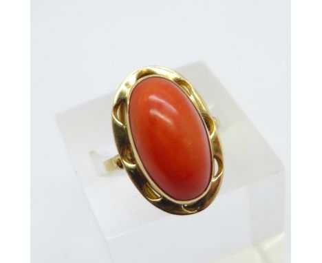 An 18ct gold ring set with a cabachon coral stone, 4.8g, N, marked 750 on the outside of the shank, coral 10mm x 18mm 