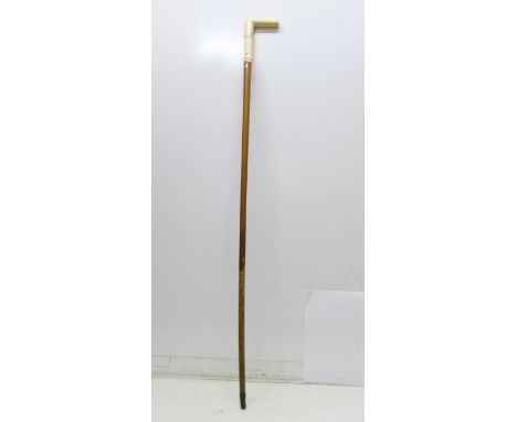 A 19th Century gentleman's walking stick, the L-shaped ivory handle carved with faux buttoned straps, malacca shaft, 86cm 