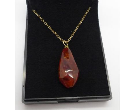 An amber pendant on a fine chain marked 375 on bolt ring, chain 1g 