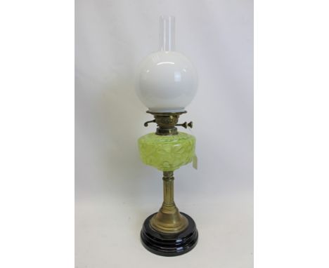 Late 19th century oil lamp with ‘English Made’ burner and moulded green glass reservoir, fluted brass column and black cerami