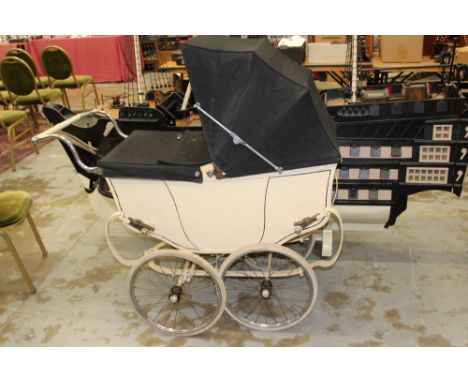 Vintage coach built perambulator in cream livery with black folding hood and cover