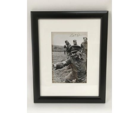 A framed and glazed signed photo of actor Clive Dunn in Dad's Army uniform and depicting fellow actors from the same TV progr