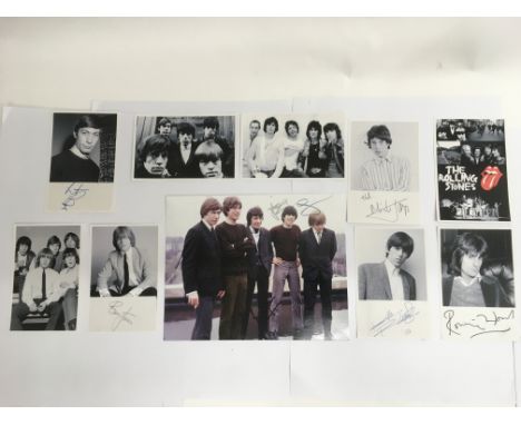 A signed photo of The Rolling Stones along with facsimile examples. Please note that there is no provenance provided with thi