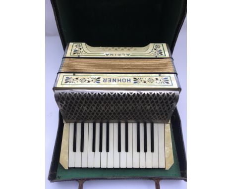 A cased Hohner Alpine accordion.