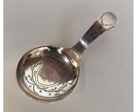 A Georgian silver bright cut caddy spoon with central shield-shaped motif. London. By TW. Approx. 6 grams. Est. £40 - £60.