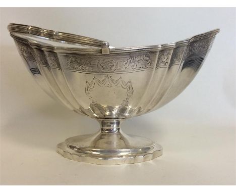 PAUL STORR & WILLIAM FRISBEE: A rare Georgian swing handled silver sugar basket attractively decorated with flowers, leaves, 