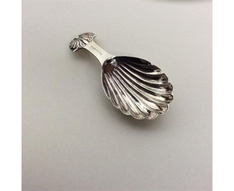 A good quality silver caddy spoon with fluted bowl and shell thumb piece. London. By RC. Approx. 14 grams. Est. £20 - £30.