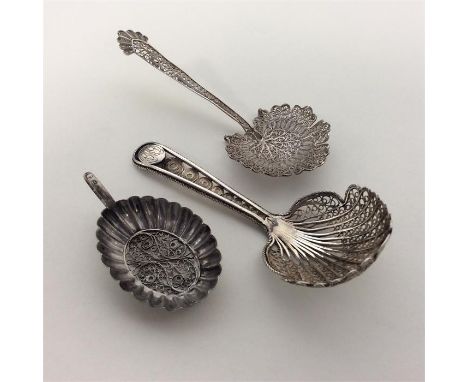 A good quality silver filigree caddy spoon together with two others. Approx. 20 grams. Est. £30 - £40.