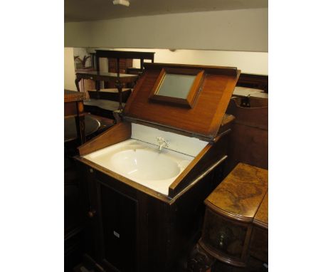 19th Century mahogany washstand, the hinged cover opening to reveal a ceramic sink above a panel door on bracket feet