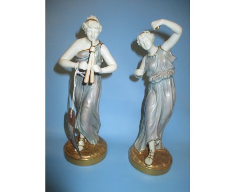 Pair of Royal Worcester gilt highlighted and blush ivory figures of classical maidens dancing with instruments, 8.5ins high