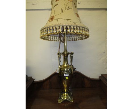 Good quality early 20th Century brass two handled vase form table lamp with mask head handles and foliate feet