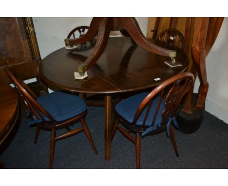 1960's Ercol dark ash drop-leaf dining room table together with a set of four matching wheelback chairs with loose cushions