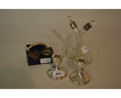 Pair of Birmingham silver dwarf candlesticks, pair of silver napkin rings, a decanter label, small frame, and a silver mounte