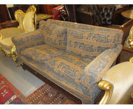 20th Century low sofa having loose cushions in blue and gold Indian style fabric with elephants and a carved moulded frieze w