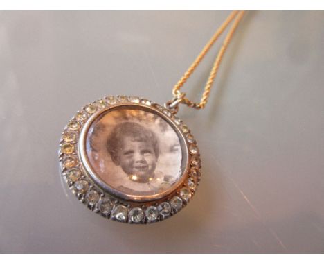 White metal and paste portrait locket on an unmarked yellow metal chain with split pearl set clasp