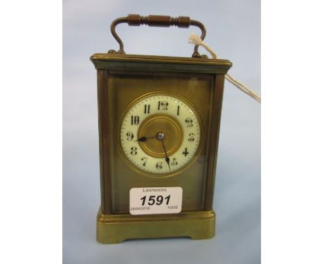 Brass carriage clock, the circular ceramic dial with Arabic numerals with a two train movement striking on a gong housed in l