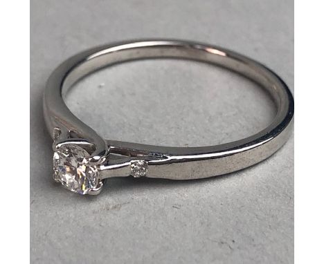 DIAMOND SOLITAIRE RING, the round brilliant cut diamond of approximately 0.30 carats,flanked by a diamond of approximately 0.