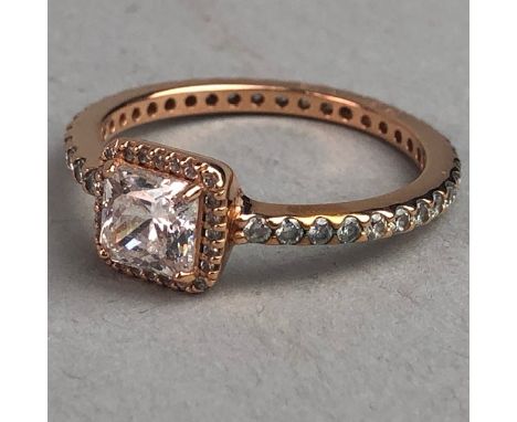 WHITE GEM SET RING, the square whire gem bordered by round white gems, with further white gems around the shank, marked O ALE